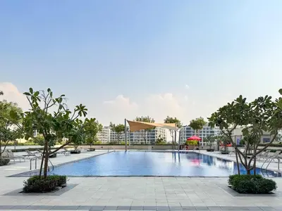 a swimming pool at a resort with trees and buildings at PVH - Acacia C - Spacious 1BR with Direct Dubai Hills Park Access in Dubai