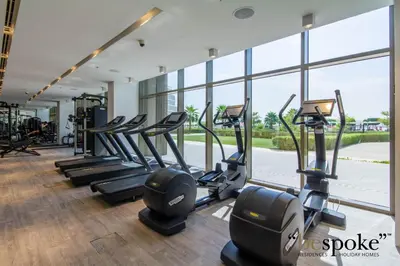 a gym with rows of treadmills and elliptical machines at Bespoke Holiday Homes - Elegant 2BR with Terrace in The 8 Palm Jumeirah in Dubai