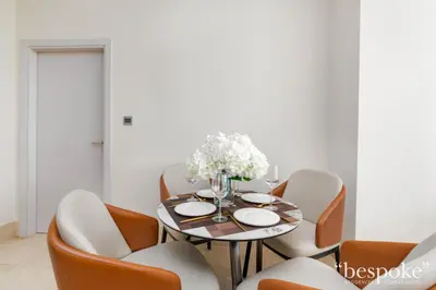 a dining room with a table and chairs at Bespoke Holiday Homes - Elegant 2BR with Terrace in The 8 Palm Jumeirah in Dubai