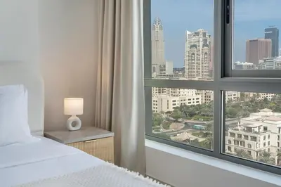 a bedroom with a bed and a large window at Greens Haven City & Golf View Balcony in Dubai