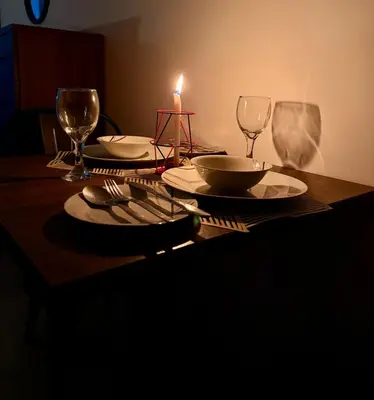 a table with a candle and plates and wine glasses at Cozy Studio in Downtown, Short walk to Burj Khalifa in Dubai