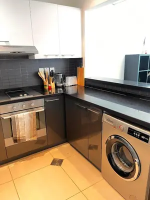 a kitchen with a washing machine and a stove at Elegant Studio, Marina access, Queen & Sofabed in Dubai
