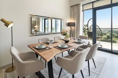 a dining room with a wooden table and chairs at Rare 4BR Vida Golf & Pool View in Dubai
