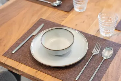 a table with a plate and a bowl and a fork and knife at Rare 4BR Vida Golf & Pool View in Dubai