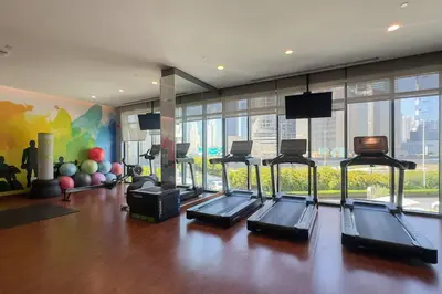 a gym with several treadmills in a room at Rare 4BR Vida Golf & Pool View in Dubai