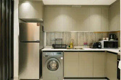a kitchen with a washing machine and a refrigerator at Brand New 1-BR with Marina and JLT Balcony Views in Dubai