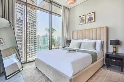 a bedroom with a bed and a large window at Frank Porter - Peninsula One in Dubai