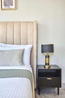 a bedroom with a bed and a lamp on a nightstand at Frank Porter - Peninsula One in Dubai