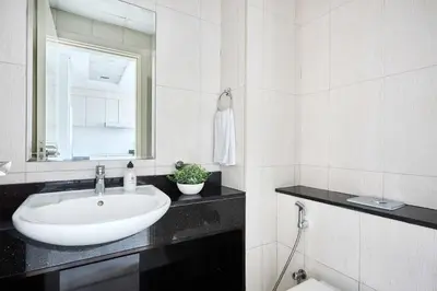 a white bathroom with a sink and a mirror at Frank Porter - Damac Ghalia in Dubai