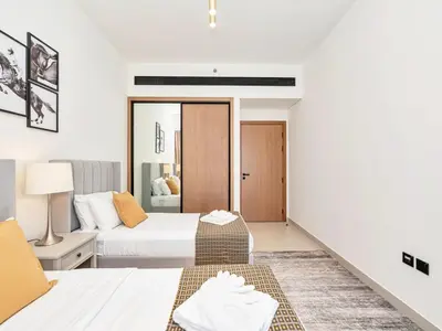 a white bedroom with two beds and a doorway at Premium 2BD with Balcony Pool & Gym in Dubai