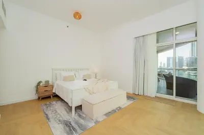 a white bedroom with a bed and a couch at Dubai Marina - Beautiful 2 Bedroom Apartment in Dubai