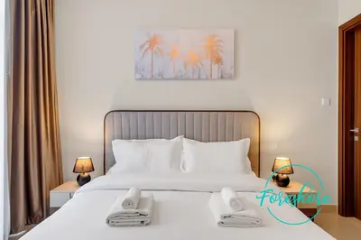 a bedroom with a large white bed with two lamps at Ultra Luxury Villa 5BR With Maid Room in Dubai