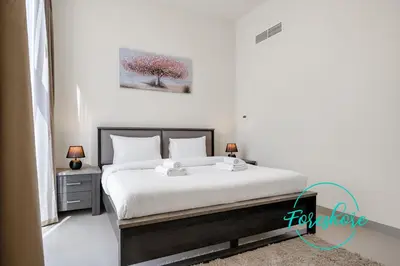 a bedroom with a bed and a tree on the wall at Ultra Luxury Villa 5BR With Maid Room in Dubai