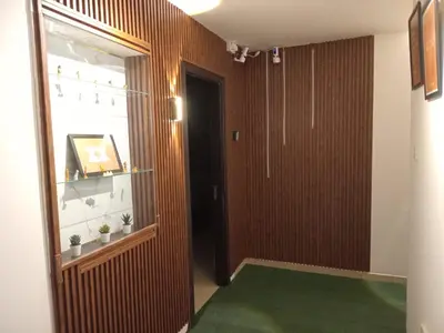 a hallway with a door and a green carpet at AlWasl Guesthouse by PHM in Dubai