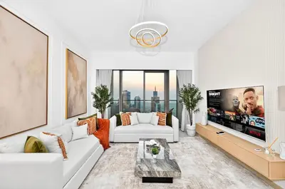 a living room with a white couch and a tv at Golden Stays - Burj View Downtown Near Dubai Mall Sleeps 11 in Dubai