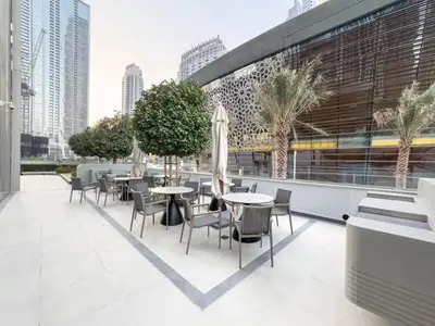 a patio with tables and chairs in a city at Golden Stays - Burj View Downtown Near Dubai Mall Sleeps 11 in Dubai