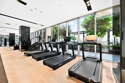 a row of treadmills in a gym with windows at Golden Stays - Burj View Downtown Near Dubai Mall Sleeps 11 in Dubai