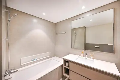 a bathroom with a tub and a sink and a mirror at Golden Stays - Burj View Downtown Near Dubai Mall Sleeps 11 in Dubai