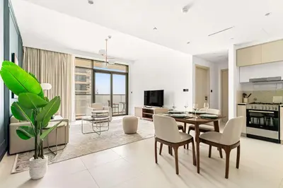 a living room and dining room with a table and chairs at Silkhaus Luxurious 1BDR with Sea View in Emaar in Dubai