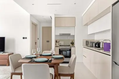 a kitchen and dining room with a wooden table and chairs at Silkhaus Luxurious 1BDR with Sea View in Emaar in Dubai