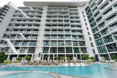 an exterior view of a large apartment building with a swimming pool at Arjan's Chic Studio with Cinema and Game Room in Dubai