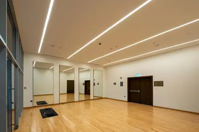 a large empty room with a wooden floor and lights at Forte 3BR Luxury PS5 Gaming Room Sleeps 9 in Dubai
