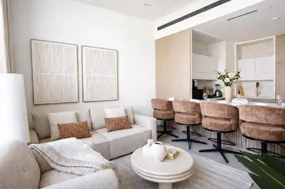 a living room with a couch and a kitchen at Stylish Stay with Plunge Pool & Scenic Pool View in Dubai
