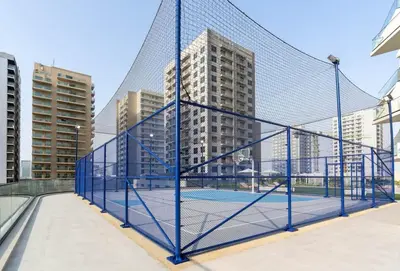 a tennis net with buildings in the background at Stylish Stay with Plunge Pool & Scenic Pool View in Dubai
