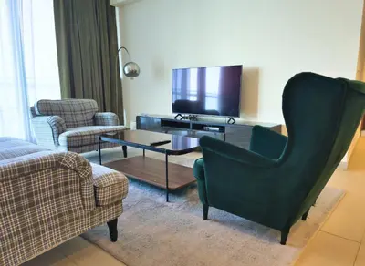 a living room with a couch and a chair and a tv at Burj VIsta 3 Bedroom - With spectacular Views in Dubai