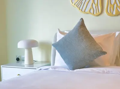 a bed with white sheets and a gray pillow on it at Burj VIsta 3 Bedroom - With spectacular Views in Dubai