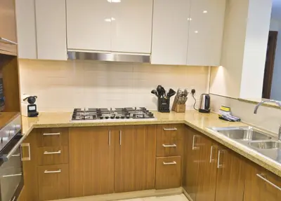 a kitchen with wooden cabinets and a stove and a sink at Burj VIsta 3 Bedroom - With spectacular Views in Dubai
