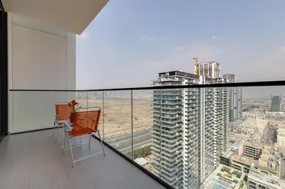 a chair on a balcony with a view of a city at Binghatti House, JVC - 1 Bedroom Apartment - Allsopp & Allsopp in Dubai