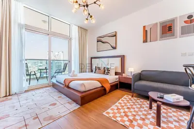 a bedroom with a bed and a couch at Skyline Studio Overlooking the Community, Only a Few Steps from the Park, Al Jawhara Tower, Jumeirah Village Triangle by Deluxe Holiday Homes in Dubai