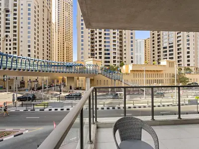 a chair on a balcony with a view of a city at Charming and Vibrant Living 1BDR In Marina Quay in Dubai