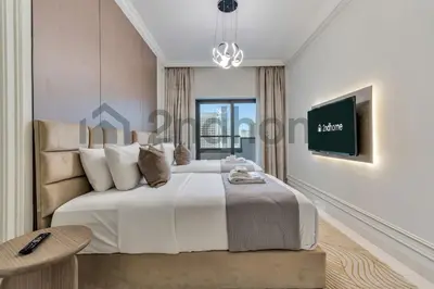 a white bedroom with a large bed and a table at Business Bay Fully Equipped 2 Bedroom Capital Bay in Dubai