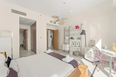 a white bedroom with a bed and a desk at VayK - Elegant Canal-Front 1 BD in a Prime Location in Dubai