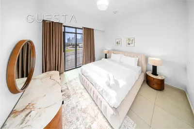 a white bedroom with a large bed and a mirror at Vida The Hills Residences, Dubai in Dubai