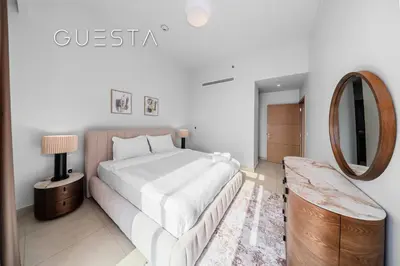 a white bedroom with a bed and a mirror at Vida The Hills Residences, Dubai in Dubai