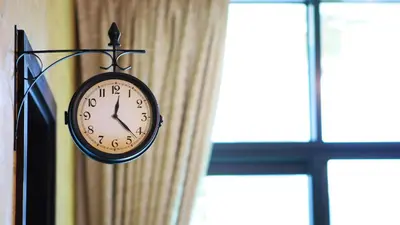 a clock hanging on a wall next to a window at Cozy 1BR in Business Bay, 10 mins to Metro in Dubai