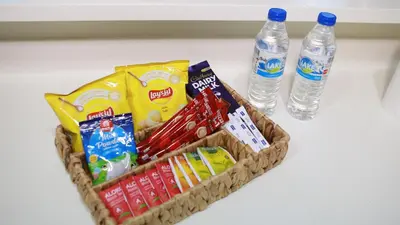a basket of candy and two bottles of water at Cozy 1BR in Business Bay, 10 mins to Metro in Dubai