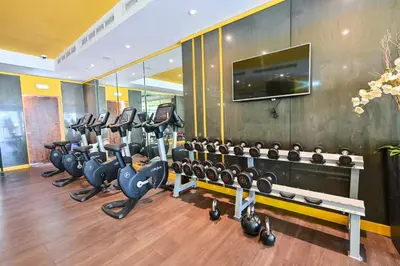 a gym with several rows of exercise equipment in a room at Cozy 1BR in Business Bay, 10 mins to Metro in Dubai
