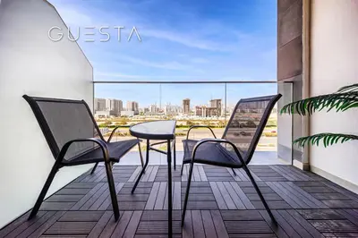 a balcony with two chairs and a view of a city at Azizi Greenfield, Meydan Dubai in Dubai