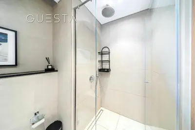 a shower with a glass door in a bathroom at Azizi Greenfield, Meydan Dubai in Dubai