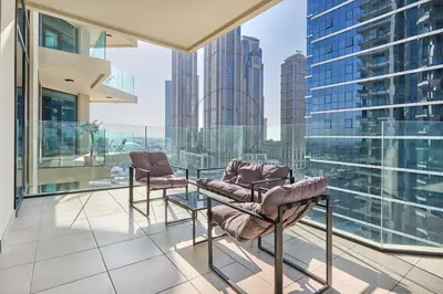 a balcony with two chairs and a glass table at Premium 2BR Apartment at Urban Oasis, Business Bay in Dubai