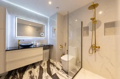 a bathroom with a toilet and a glass shower at Bright 2BR Marina View with Balcony in Dubai