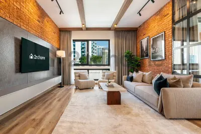 a living room with a couch and a tv on a brick wall at Luxurious Newly Furnished 2 Bed in Dubai Marina in Dubai