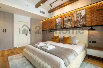 a bedroom with a large bed and a brick wall at Luxurious Newly Furnished 2 Bed in Dubai Marina in Dubai