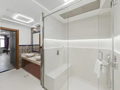 a bathroom with a glass shower and a sink at DVH Al Basri Palm Beachfront 2BR Full Sea Views in Dubai