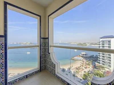 a balcony with a view of the beach and ocean at DVH Al Basri Palm Beachfront 2BR Full Sea Views in Dubai