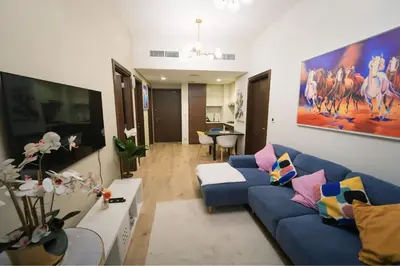 a living room with a blue couch and a table at Luxury 2BR in Business Bay Close to Dubai Mall in Dubai